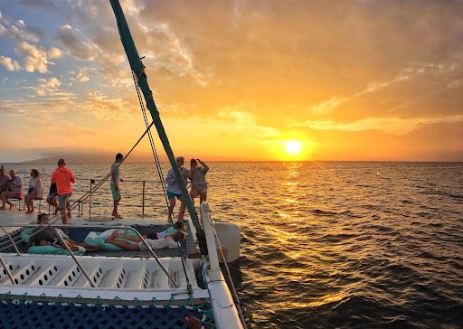People on a boat watching a sunset over the ocean.