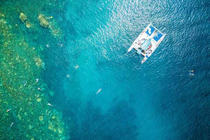 aerial view of a catamaran and swimmers